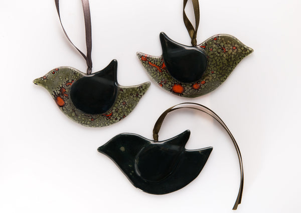 Mīlīgs stikla putns tumšos toņos