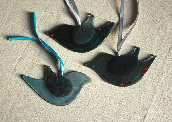 Mīlīgs stikla putns tumšos toņos