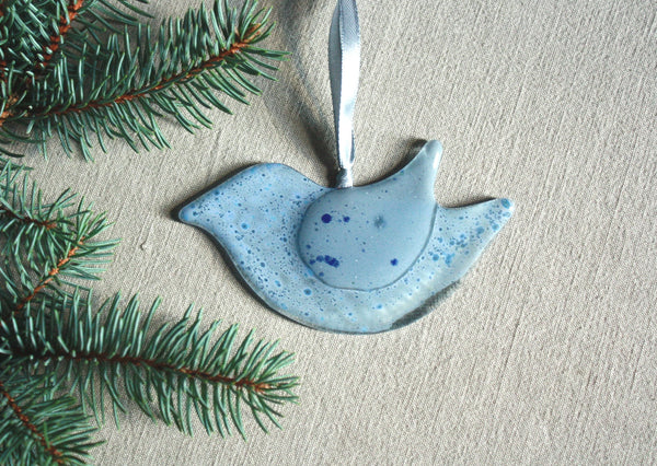 Mīlīgs stikla putns, apgleznots pelēkos un zaļganos toņos